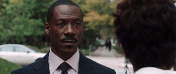 Movie still from “Imagine That” (2009), directed by Karey Kirkpatrick – A person wearing a suit and tie; Close Up shot, Over the shoulder angle