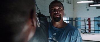 Movie still from “Imagine That” (2009), directed by Karey Kirkpatrick – A person with a boxing bag; Close Up shot, Over the shoulder angle