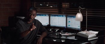 Movie still from “Imagine That” (2009), directed by Karey Kirkpatrick – A man sitting in front of three computer monitors; Medium shot, Over the shoulder angle