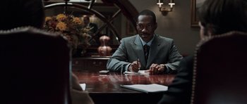 Movie still from “Imagine That” (2009), directed by Karey Kirkpatrick – A man sitting at a table writing on a piece of paper; Medium shot, Over the shoulder angle