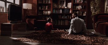 Movie still from “Imagine That” (2009), directed by Karey Kirkpatrick – A man and a boy sitting on the ground in a room; Wide shot, High angle