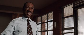 Movie still from “Imagine That” (2009), directed by Karey Kirkpatrick – A man wearing a tie standing next to a window; Close Up shot, Low angle