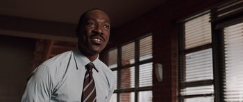 Movie still from “Imagine That” (2009), directed by Karey Kirkpatrick – A person wearing a suit and a tie; Close Up shot, Low angle