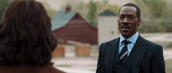 Movie still from “Imagine That” (2009), directed by Karey Kirkpatrick – A man wearing a suit and tie standing next to a woman; Close Up shot, Over the shoulder angle