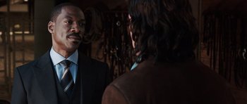 Movie still from “Imagine That” (2009), directed by Karey Kirkpatrick – A man standing next to another man in front of a mirror; Close Up shot, Over the shoulder angle