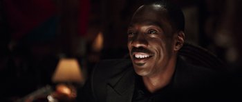 Movie still from “Imagine That” (2009), directed by Karey Kirkpatrick – A person wearing a suit and smiling; Close Up shot, Low angle