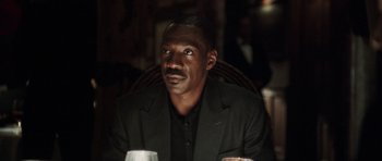 Movie still from “Imagine That” (2009), directed by Karey Kirkpatrick – A man sitting at a table with a glass of wine in front of him; Close Up shot, Low angle