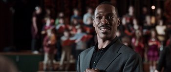 Movie still from “Imagine That” (2009), directed by Karey Kirkpatrick – A man standing in front of a group of people; Close Up shot, Low angle