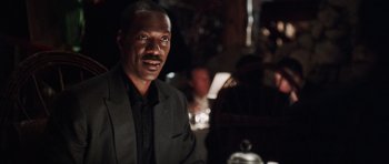 Movie still from “Imagine That” (2009), directed by Karey Kirkpatrick – A man wearing a suit and tie in front of a mirror; Close Up shot, Over the shoulder angle