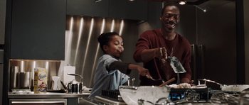 Movie still from “Imagine That” (2009), directed by Karey Kirkpatrick – A man and a girl in a kitchen preparing a meal; Medium shot, Low angle