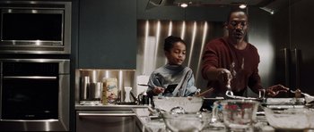 Movie still from “Imagine That” (2009), directed by Karey Kirkpatrick – A young girl in a kitchen preparing a meal; Medium shot, Over the shoulder angle