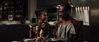 Movie still from “Imagine That” (2009), directed by Karey Kirkpatrick – A man and a girl sitting at a table with pancakes; Medium shot, Over the shoulder angle