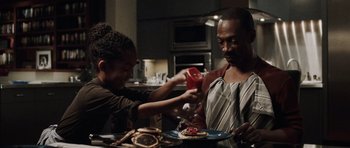 Movie still from “Imagine That” (2009), directed by Karey Kirkpatrick – A man and a woman preparing food in a kitchen; Medium shot, Over the shoulder angle