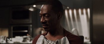 Movie still from “Imagine That” (2009), directed by Karey Kirkpatrick – A person wearing an apron in a kitchen; Close Up shot, Over the shoulder angle