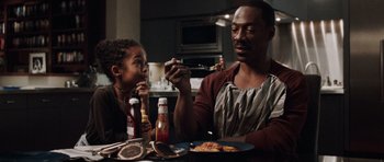 Movie still from “Imagine That” (2009), directed by Karey Kirkpatrick – A man and a child sitting at a dinner table; Medium shot, Over the shoulder angle