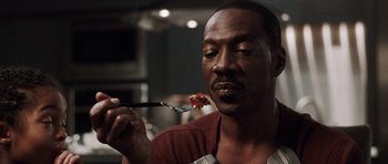 Movie still from “Imagine That” (2009), directed by Karey Kirkpatrick – A person holding a fork with food on it; Close Up shot, High angle