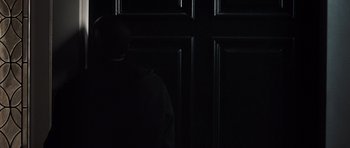 Movie still from “Imagine That” (2009), directed by Karey Kirkpatrick – A person standing in front of a black door; Medium shot, Low angle