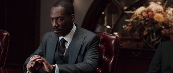 Movie still from “Imagine That” (2009), directed by Karey Kirkpatrick – A man in a suit and tie sitting in a chair; Close Up shot, Over the shoulder angle