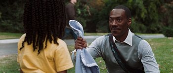 Movie still from “Imagine That” (2009), directed by Karey Kirkpatrick – A man is holding a towel while a woman looks on; Medium shot, Over the shoulder angle