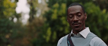 Movie still from “Imagine That” (2009), directed by Karey Kirkpatrick – A person wearing a suit and tie; Close Up shot, Over the shoulder angle