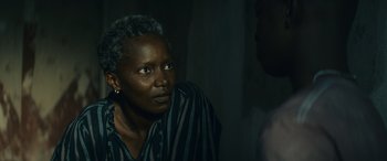 An older woman is sitting in a dark room