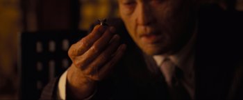 Movie still from “Inception” (2010), directed by Christopher Nolan – A man holding a cigarette in his hands; Extreme Close Up shot, High angle