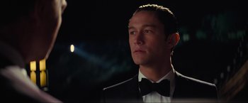 Movie still from “Inception” (2010), directed by Christopher Nolan – A man in a suit and bow tie looking to his left; Close Up shot, Low angle