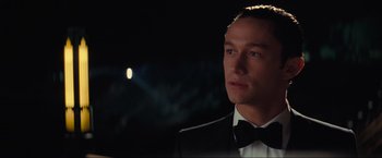 Movie still from “Inception” (2010), directed by Christopher Nolan – A person wearing a suit and bow tie; Close Up shot, Over the shoulder angle