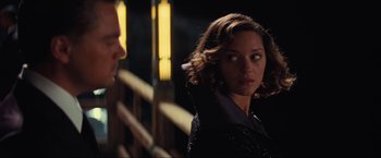 Movie still from “Inception” (2010), directed by Christopher Nolan – A man and a woman standing next to each other in front of lights; Close Up shot, Over the shoulder angle
