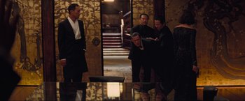 Movie still from “Inception” (2010), directed by Christopher Nolan – A group of men standing around a table; Wide shot, High angle