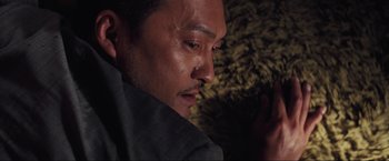 Movie still from “Inception” (2010), directed by Christopher Nolan – A person looking down at something; Close Up shot, Low angle