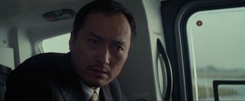 Movie still from “Inception” (2010), directed by Christopher Nolan – A person wearing a suit and tie; Close Up shot, Low angle