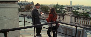 Movie still from “Inception” (2010), directed by Christopher Nolan – A man and a woman standing on a balcony looking at each other; Wide shot, Low angle