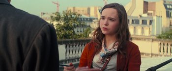 Movie still from “Inception” (2010), directed by Christopher Nolan – A young woman holding a cell phone while standing next to a river; Close Up shot, Over the shoulder angle