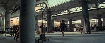 Movie still from “Inception” (2010), directed by Christopher Nolan – A person walking in an empty warehouse; Extreme Wide shot, High angle