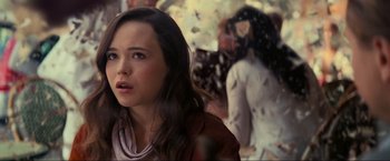 Movie still from “Inception” (2010), directed by Christopher Nolan – A young woman is standing in front of a group of people; Close Up shot, Over the shoulder angle