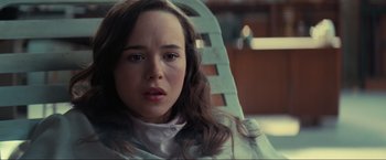 Movie still from “Inception” (2010), directed by Christopher Nolan – A woman sitting in a chair looking at the camera; Close Up shot, Over the shoulder angle