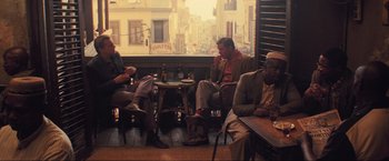 Movie still from “Inception” (2010), directed by Christopher Nolan – A group of men sitting at a table in a restaurant; Wide shot, High angle