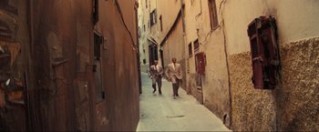 Movie still from “Inception” (2010), directed by Christopher Nolan – A couple of men walking down a narrow alley way; Wide shot, High angle