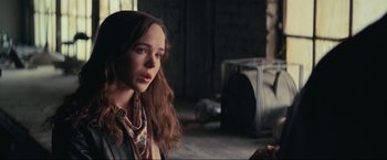 Movie still from “Inception” (2010), directed by Christopher Nolan – A woman with long brown hair wearing a neck tie; Close Up shot, Over the shoulder angle