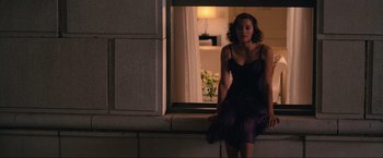 Movie still from “Inception” (2010), directed by Christopher Nolan – A woman standing in front of a window in front of a building; Medium shot, High angle