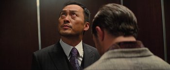 Movie still from “Inception” (2010), directed by Christopher Nolan – A man in a suit and tie looking at himself in the mirror; Close Up shot, Low angle
