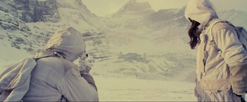 Movie still from “Inception” (2010), directed by Christopher Nolan – A man in a white jacket is looking out at a snowy mountain range; Wide shot, Over the shoulder angle