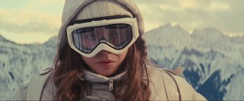 Movie still from “Inception” (2010), directed by Christopher Nolan – A woman wearing a white jacket and a pair of ski goggles; Close Up shot, Low angle