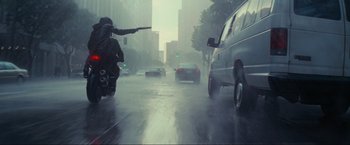 Movie still from “Inception” (2010), directed by Christopher Nolan – A person on a motorcycle in the middle of the street; Wide shot, Low angle