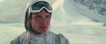 Movie still from “Inception” (2010), directed by Christopher Nolan – A man wearing a white ski suit and goggles; Close Up shot, Over the shoulder angle