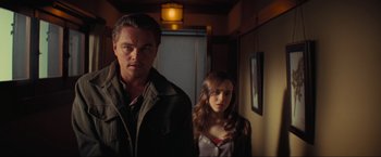 Movie still from “Inception” (2010), directed by Christopher Nolan – A man and a woman standing next to each other in a hallway; Medium shot, Low angle