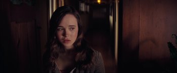 Movie still from “Inception” (2010), directed by Christopher Nolan – A woman with long hair is standing in a dark room; Close Up shot, Over the shoulder angle