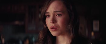 Movie still from “Inception” (2010), directed by Christopher Nolan – A person looking sad with her eyes wide open; Close Up shot, Over the shoulder angle