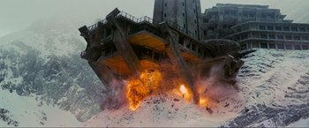 Movie still from “Inception” (2010), directed by Christopher Nolan – An explosion is seen in front of a building; Extreme Wide shot, Low angle